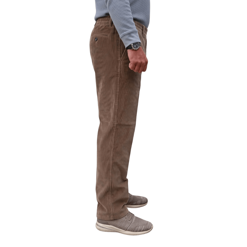 Profilo laterale di pantaloni in velluto a coste marroni con elastico in vita e tasca frontale, indossati da una persona