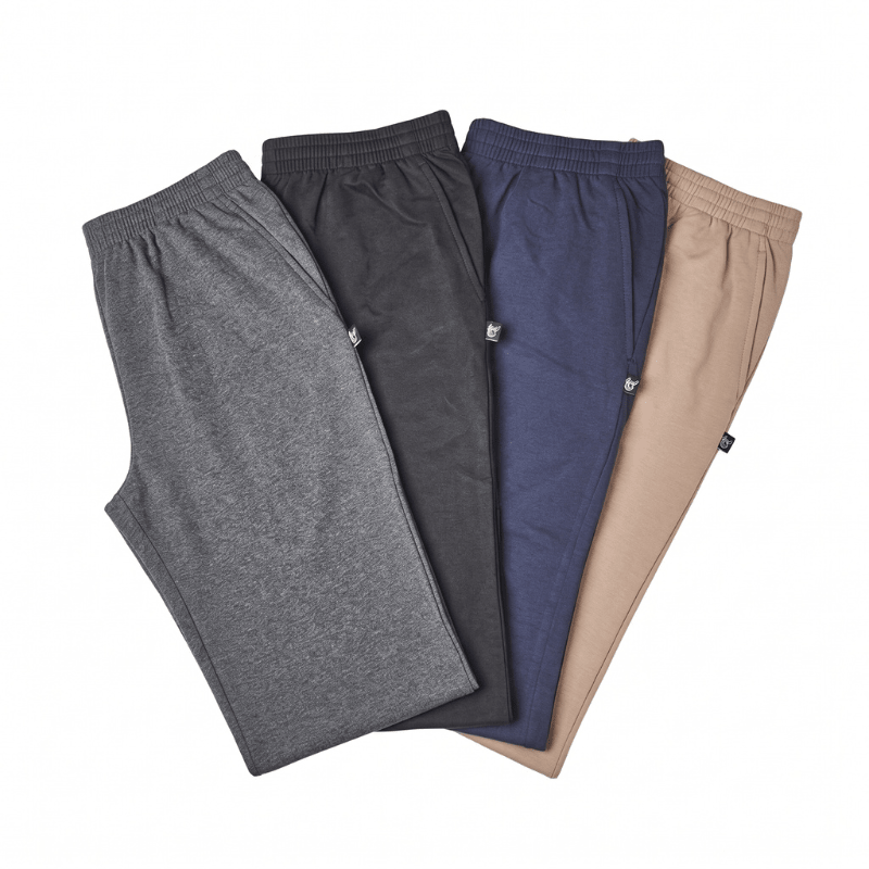 Quattro paia di pantaloni da jogging grigi, neri, blu e beige, visti dall'alto con elastico in vita e tasche laterali