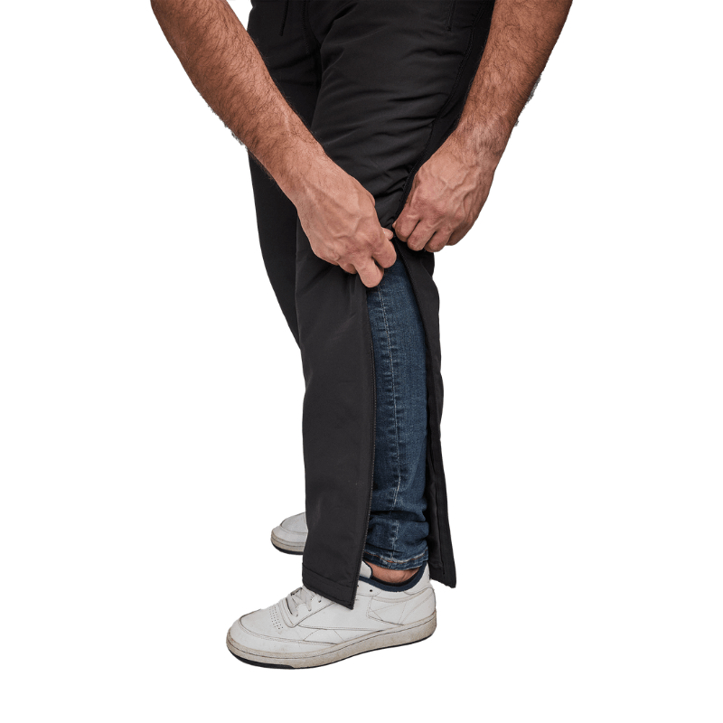 Primo piano di mani che aprono pantaloni termici Dobsom lateralmente sopra i jeans