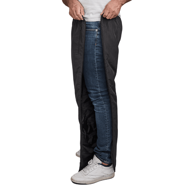 Uomo apre pantaloni termici Dobsom neri lateralmente, sopra jeans blu e sneakers bianche
