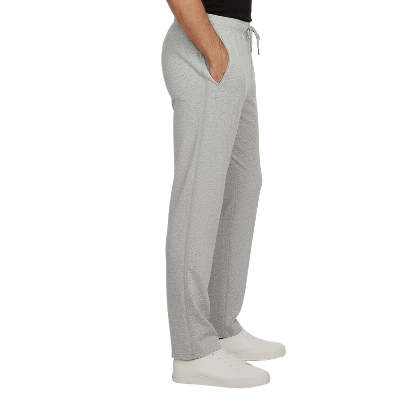 Pantaloni da jogging grigi con cerniere laterali chiuse e tasche, visti di lato su una persona