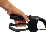 Primo piano di una mano che impugna la maniglia ergonomica e la leva del freno di un rollator