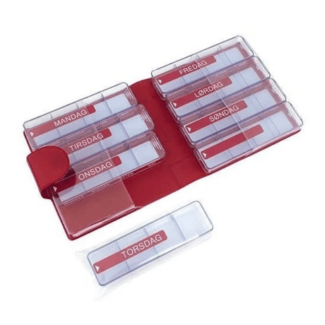 Astuccio rosso in similpelle aperto con sette portapillole trasparenti e una scatola separata con giorni e orari