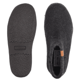 Due pantofole Green Comfort nere in feltro di lana, una mostra la suola in gomma antiscivolo, l'altra la parte superiore